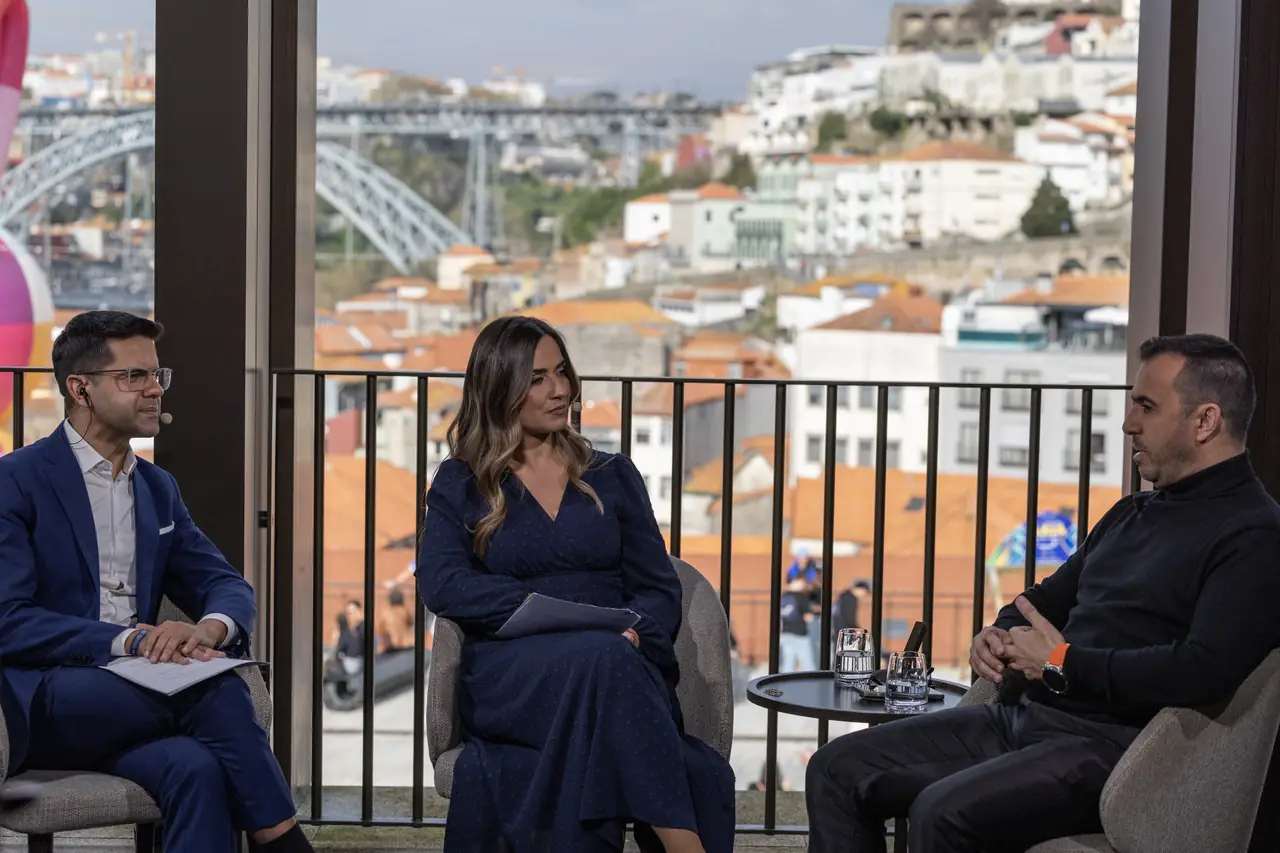Entrevista de televisão numa varanda com vista sobre o Porto e o rio Douro.