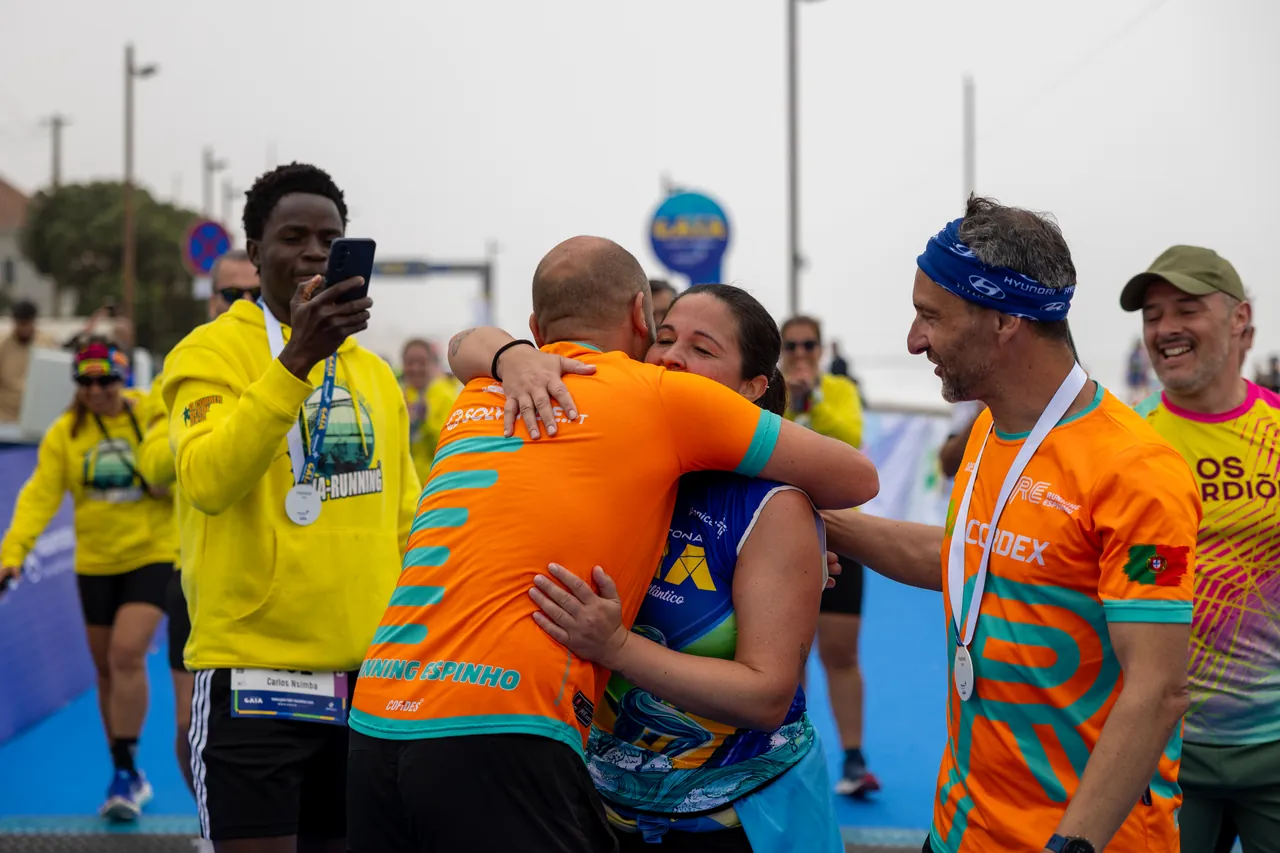 Grupo de amigos festeja em conjunto, com abraços, perto da meta: fotograma de capa do vídeo oficial da Meia Maratona de Gaia 2026.