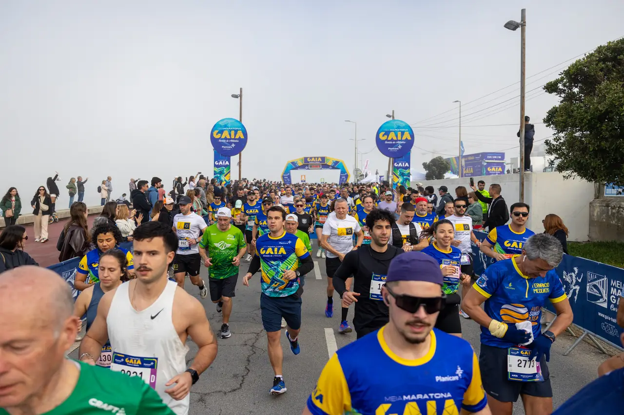Um grupo de corredores da Meia Maratona de Gaia 2026 visto de frente, com o pelotão a encher a estrada atrás deles.