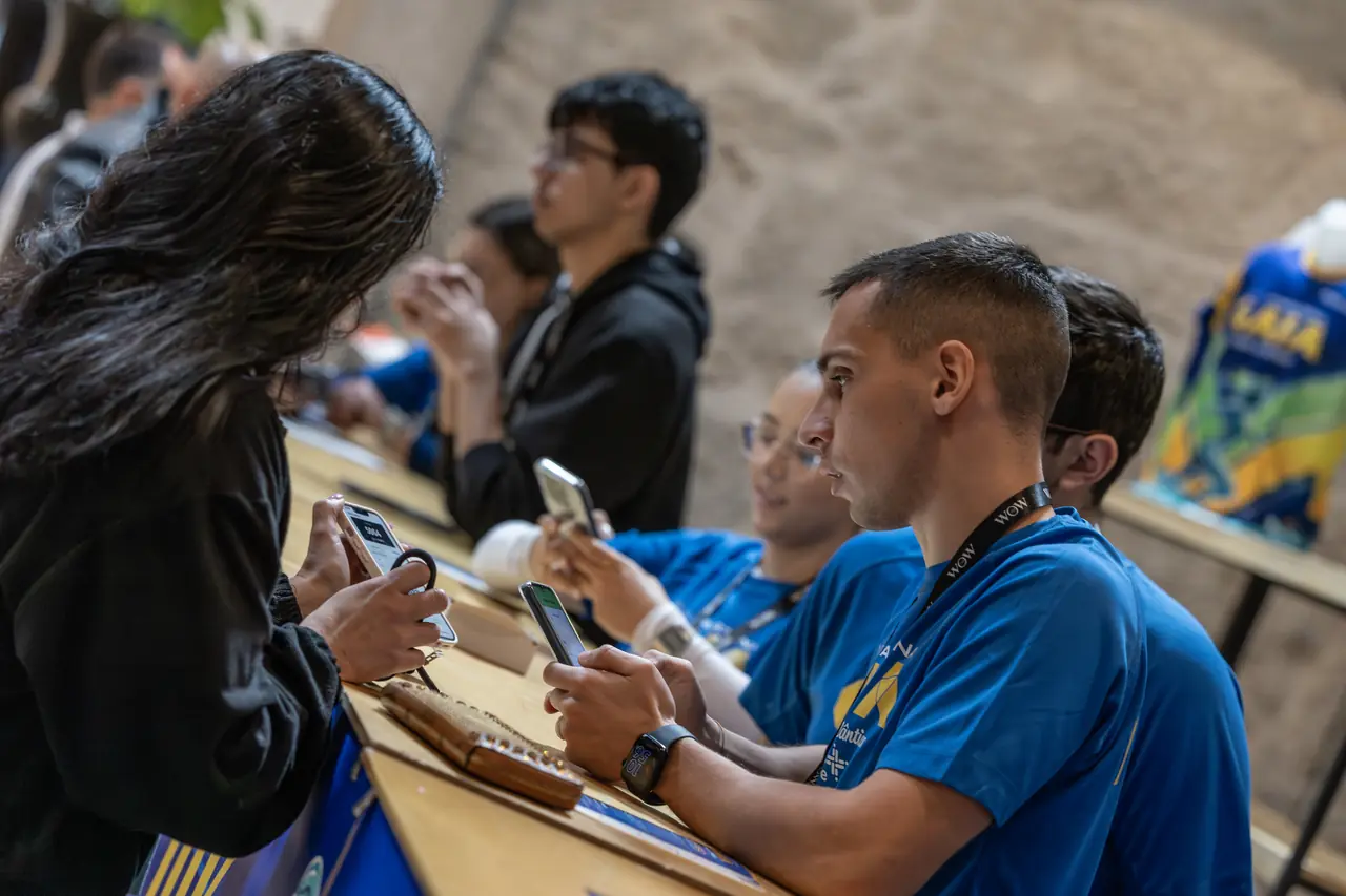 Voluntários da organização a atender participantes na banca do secretariado, no dia anterior à prova de 2026.